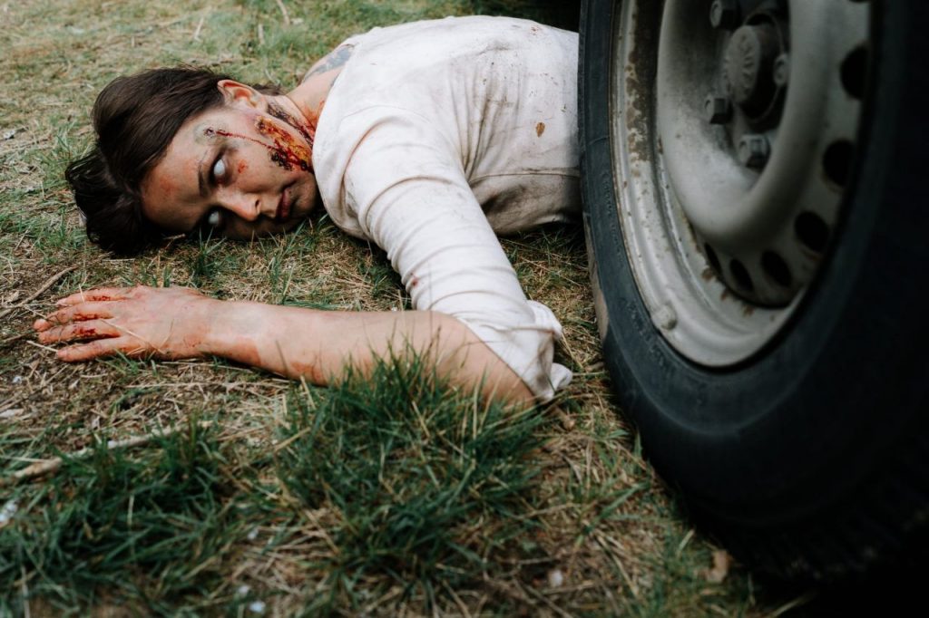 zombie lying underneath a car
