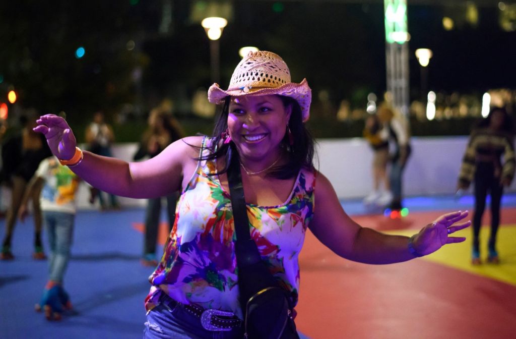 Una mujer celebra mientras patina sobre ruedas durante una fiesta para escuchar el nuevo álbum de Beyoncé "Cowboy Carter"