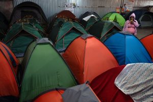 Una mujer migrante permanece frente a su tienda de campaña en el albergue Juventud 2000, en Tijuana, Baja California.
